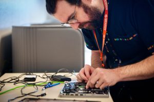 Encantado technician Zachariah Bassett works on a Sandia National Laboratories laptop with a battery that cannot charge at the Swift IT Bar in Building 801. (Photo by Craig Fritz) Click on the thumbnail for a high-resolution image.