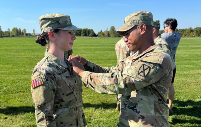 After competing in the Expert Field Medical Badge Competition, 1st Lt. Spencer Blankenship gets the badge pinned onto her uniform at Fort Drum, New York.