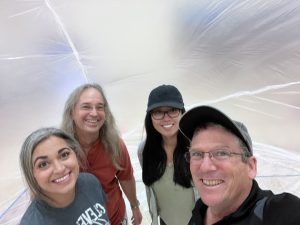 Dan Small, right, takes a selfie with (right to left) fellow Sandia National Laboratories volunteers Jessica Lien and David Novick, and Cleveland Middle School Science chair Vanessa Gonzales at the 2024 balloon launch event. (Photo by Dan Small) Click on the thumbnail for a high-resolution image.