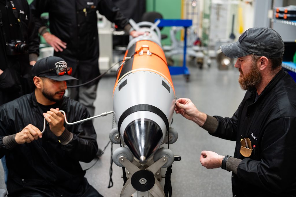 Two technologists at Sandia National Laboratories place the final screws in a B61-13 high-fidelity unit. The B61-13 first production unit was completed in May at the Pantex Plant, and is one of the most rapidly developed and fielded weapons since the Cold War. (Photo by Craig Fritz) Click on the thumbnail for a high-resolution image.