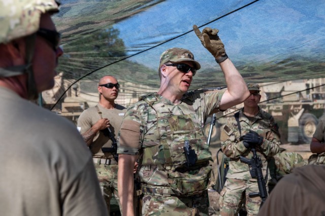 U.S. Army reservist Lt. Col. Robert Fincher, commander of 934th Forward Resuscitative Surgical Detachment, teaches his Soldiers the capabilities of specific camo netting that provides concealment from drones flying in the area during Exercise...