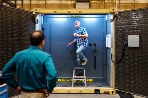 An engineer adjusts sensors inside of the Mobile Vault’s vestibule at Sandia National Laboratories while another watches. (Photo by Craig Fritz) Click on the thumbnail for a high-resolution image.