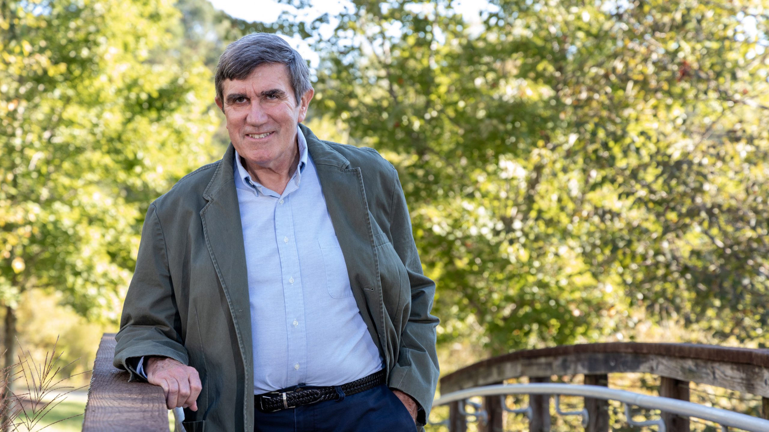 Outdoor image of an ORNL researcher leaning on a bridge. 