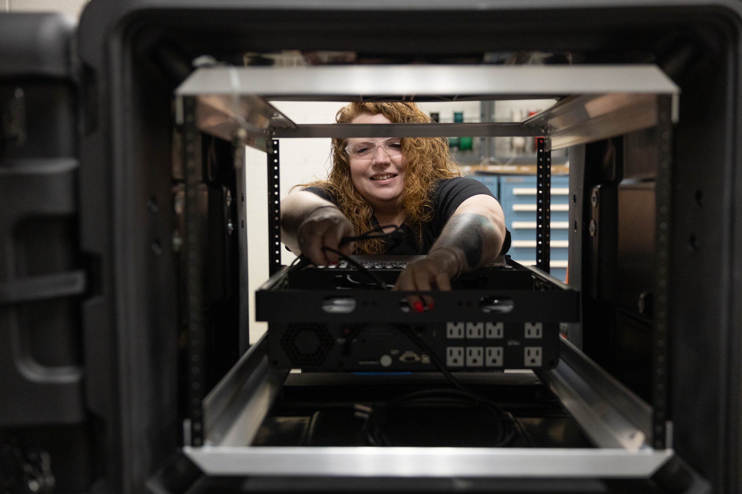 ORNL researcher Christi Johnson is reaching inside a cabinet  