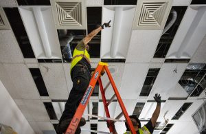Eli Vasquez, left, and David Garcia, both from Strategic Industry Inc., work to update electrical connections in a room at the Saturn pulsed-power generator facility at Sandia National Laboratories. (Photo by Craig Fritz) Click on the thumbnail for a high-resolution image.