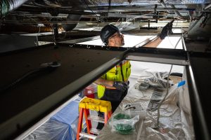 Eli Vasquez from Strategic Industry Inc. works to update electrical connections in a room at the Saturn pulsed-power generator facility at Sandia National Laboratories. (Photo by Craig Fritz) Click on the thumbnail for a high-resolution image.