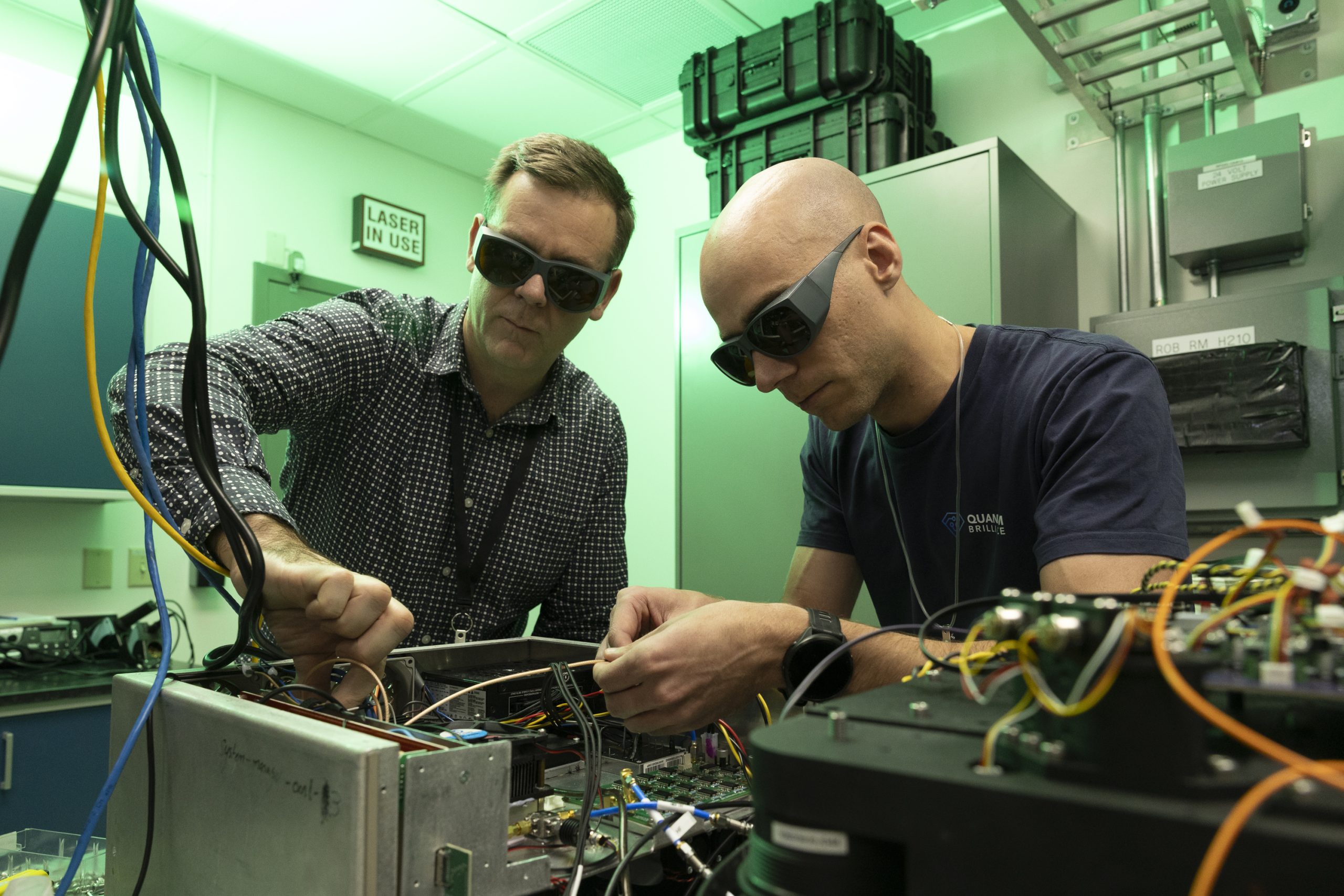 Quantum Brilliance's Quantum Development Kits use diamond-based quantum processing units that operate at room temperature in a relatively small package. A team of Quantum Brilliance engineers, including (from left) Leigh Cameron and Cameron Walters, reassembled and calibrated the system in ORNL's laser calibration laboratory. 